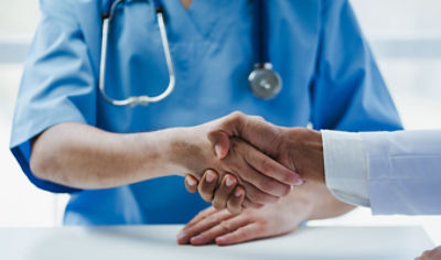 A doctor and a nurse shaking hands