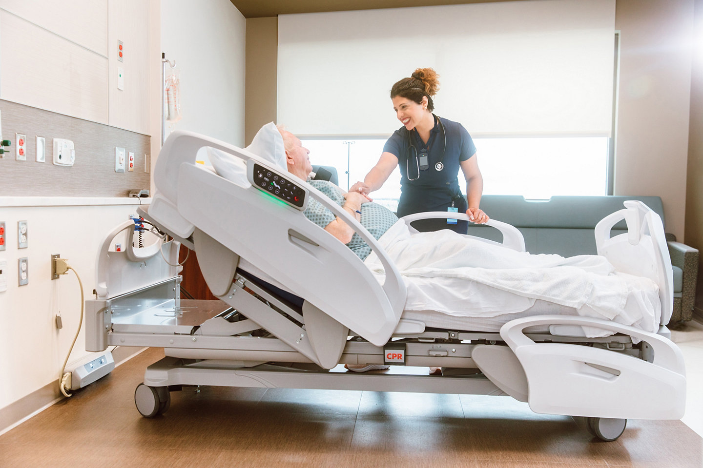 Nurse communicating with patient in a hospital bed
