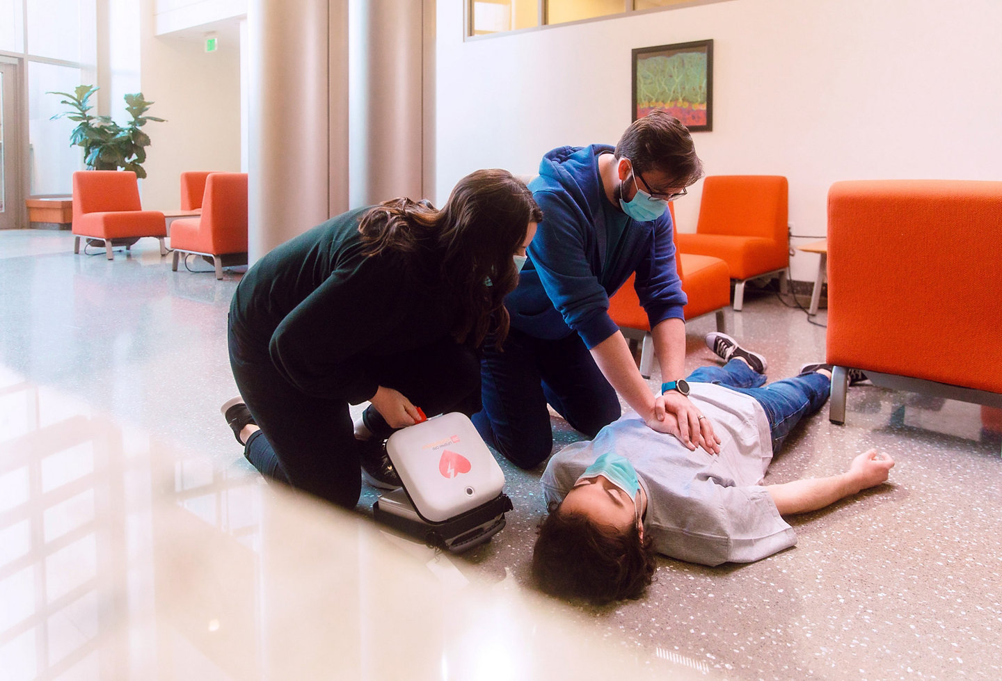 Bystanders perform CPR and prepare a LIFEPAK CR2 AED for use on a sudden cardiac arrest victim