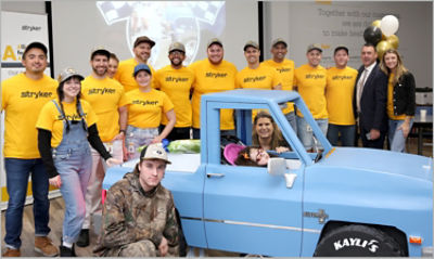 Stryker Sage's build team posing with wheelchair Halloween costume for family.