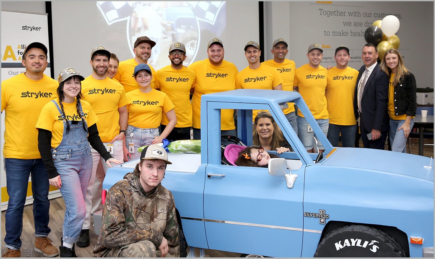 Stryker Sage's build team posing with wheelchair Halloween costume for family.