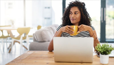 Woman sitting at laptop reviewing workplace AED management software 