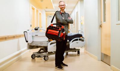 Stryker ProCare medical device tech standing in a hospital hallway