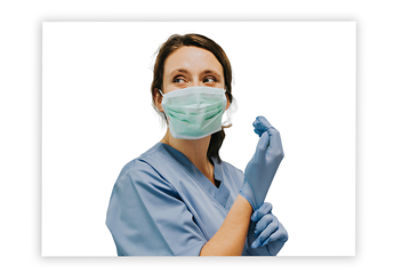 Female nurse putting on gloves in an operating room