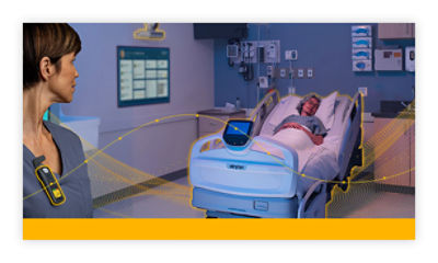 Connected hospital room with patient in bed and digital monitoring system in use