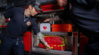 Firemen grabbing gear from their truck, including a LIFEPAK CR2