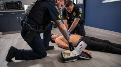 Two police officers using a LIFEPAK CR2