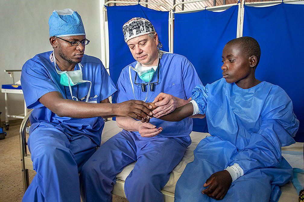 General Surgery Resident Yves Nezerwa Rwanda and Cleft Surgeon Steve Naum USA assessing wrist contracture with patient Solange