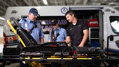 ProCare technician giving demonstration of Stryker cot to emergency responders