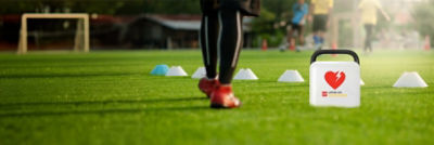 Soccer player stands next to a LIFEPAK CR2 AED on the  field