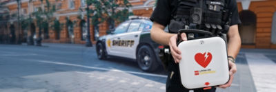 Police officer holding a LIFEPAK CR2 AED