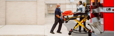 Paramedic uses a Power-PRO 2 powered ambulance cot to load a patient into the back of an ambulance