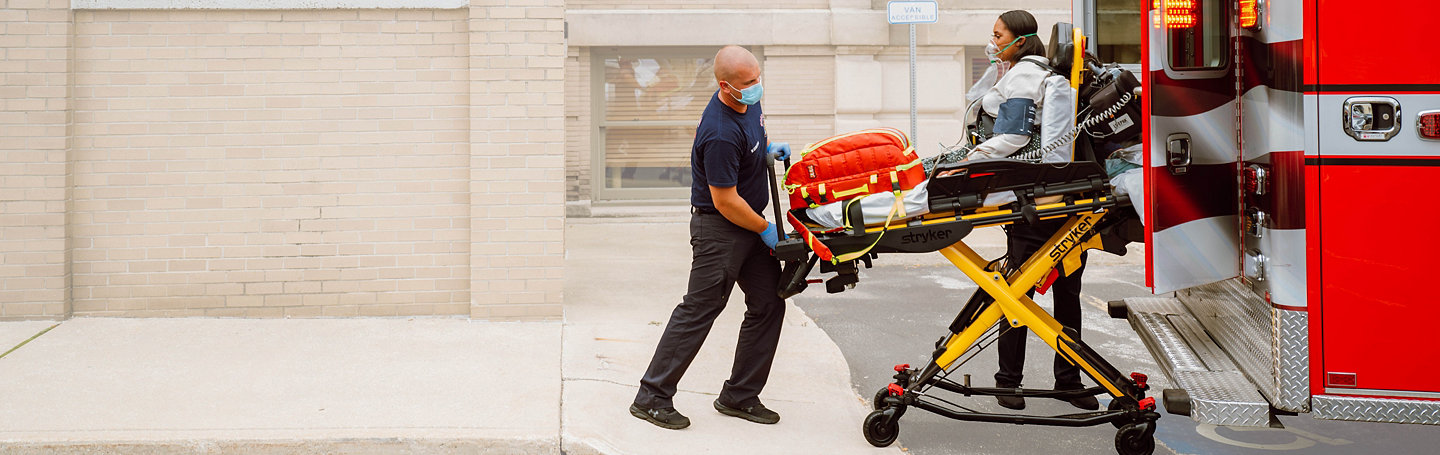 Paramedic uses a Power-PRO 2 powered ambulance cot to load a patient into the back of an ambulance