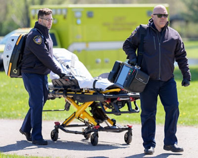 Two EMTs pushing a Power-PRO 2 and holding a LUCAS device and LIFEPAK 35 monitor/defibrillator