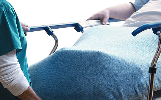 Patiënt die comfortabele bedieningselementen gebruikt op een Prime-brancard van Stryker