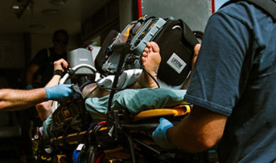 EMTs transport patient into the back of an ambulance