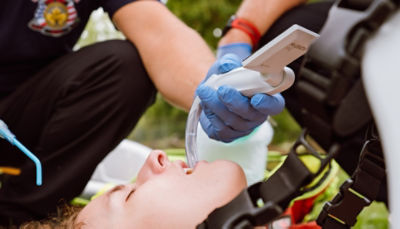 Two EMTs use the McGRATH MAC video laryngoscope on a young patient in the field 