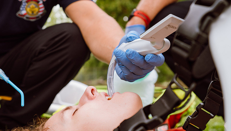 Two EMTs use the McGRATH MAC video laryngoscope on a young patient in the field 