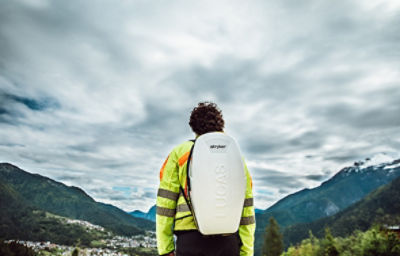 Rettungskraft beim Tragen eines LUCAS 3-Thoraxkompressionssystems in einem Rucksack auf dem Rücken