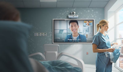 A Virtual Nurse calling into a patient's room while an on-site nurse performs bedside care duties