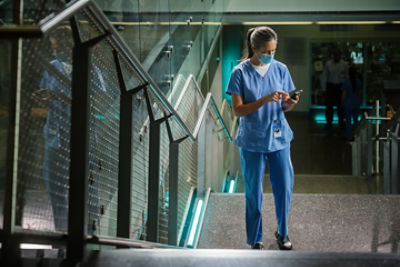Nurse reviewing alerts and patient data using Vocera's collaboration suite 