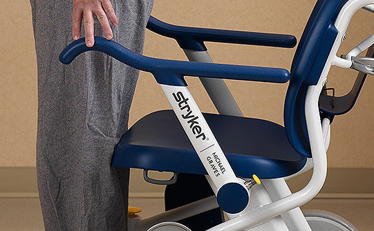 Patient using the stand assist armrests on the Prime TC transport chair 