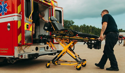 EMT loading a Power-PRO XT powered ambulance cot into an ambulance