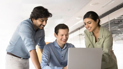 Business people in conversation gathered around computer screen