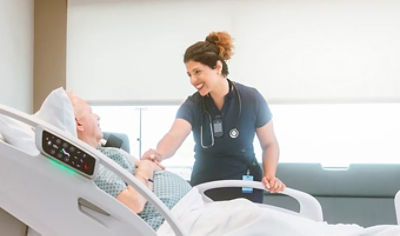 Nurse caring for patient in Stryker hospital bed 