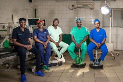 El Dr. Charles y el Dr. Ntirenganya posan para una foto con los Dres. Nezerwa, Mukagaju y Shyaka en el programa de residencia en cirugía plástica de la Universidad de Ruanda.