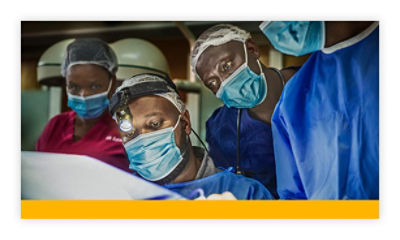 Dr Clovis Baramburiye performs surgery while surgical residents observe in Rwanda, Africa