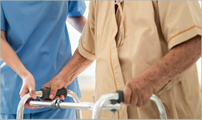 Nurse helping patient with walker