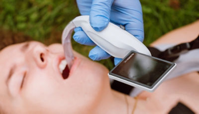An EMT is shown using the McGRATH MAC video laryngoscope on a patient in the field