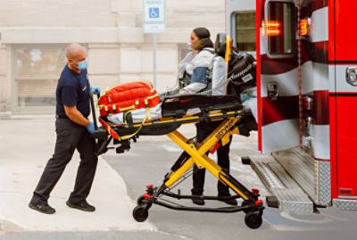 Paramedic loads patient into an ambulance on a Power-PRO powered cot 