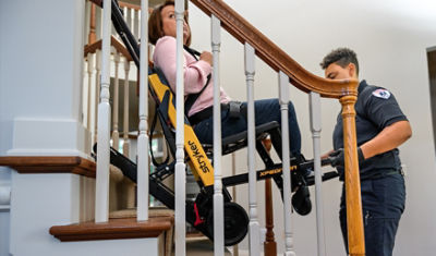 First responders using an Xpedition powered stair chair to transport a patient