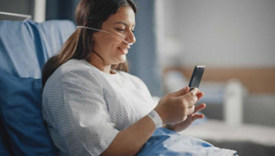 Patient sitting up in hospital bed talking on phone