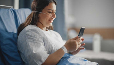Patient sitting up in hospital bed talking on phone