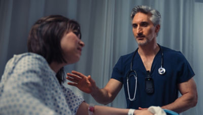 Nursing calmly consoling patient in hospital bed