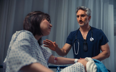 Nursing calmly consoling patient in hospital bed