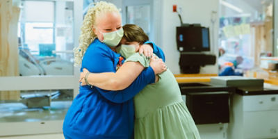 An RN hugs a patient in the hospital 