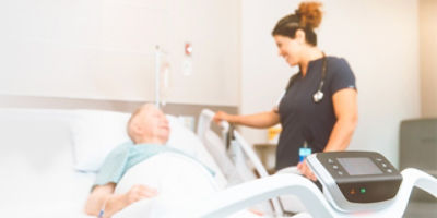 Nurse caring for patient in Stryker's Procuity hospital bed