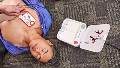 patient lying on floor wearing stickers simulating AED pad placement