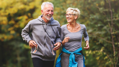 Couple running together outdoors, enjoying being pain-free after balloon kyphoplasty treatment