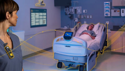 Connected hospital room with patient in bed and digital monitoring system in use