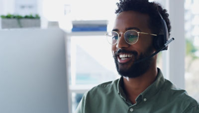 A customer service representative wears a headset while speaking to customer 