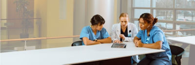 Three medical professionals discuss patient data using data professional services
