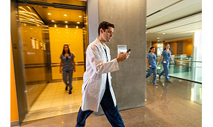 Doctors and nurses walking in a hospital wearing Vocera Badges - hands-free communication devices