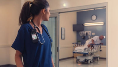 nurse looking back toward patient getting out of hospital bed