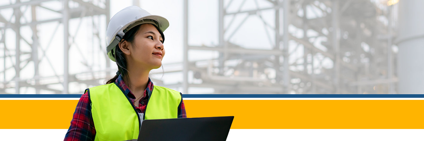 Woman in construction gear holding laptop