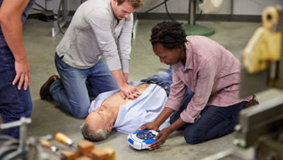 Man performing CPR on man lying on ground